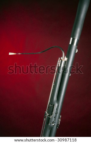 A Bassoon music instrument isolated against a red spotlight with copy space in the vertical format.