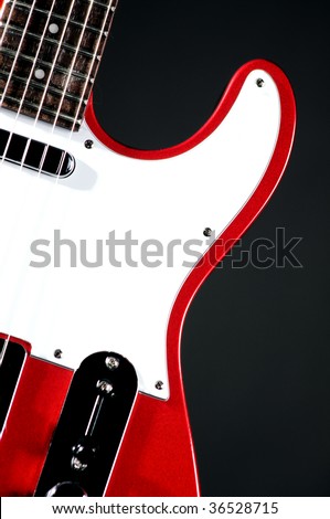 An electric metallic red guitar isolated on a black background in the  vertical format with copy space.