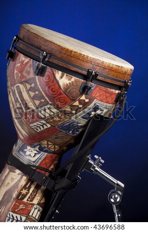 An African  or Latin djembe conga drum isolated against a spotlight blue background.