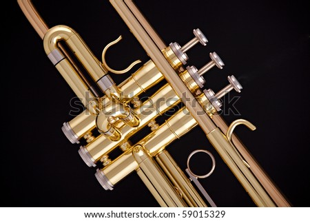 A professional gold trumpet isolated against a black background in the horizontal format.