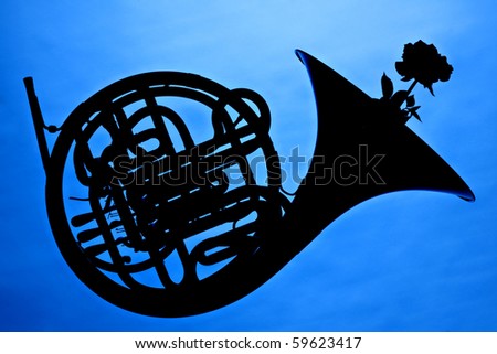 A French horn and rose flower in silhouette isolated against a blue background.