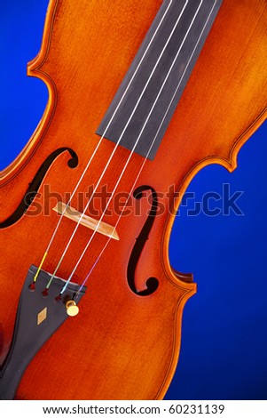 A violin viola body isolated against a blue background in the vertical format.