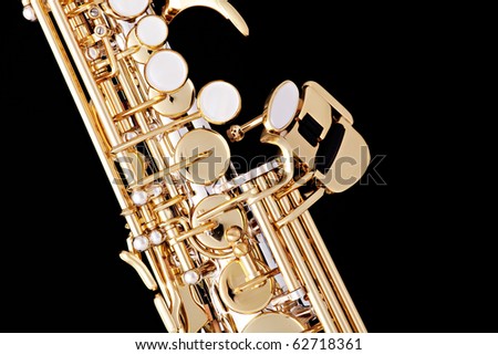 A professional gold soprano sax up close isolated against a black background.