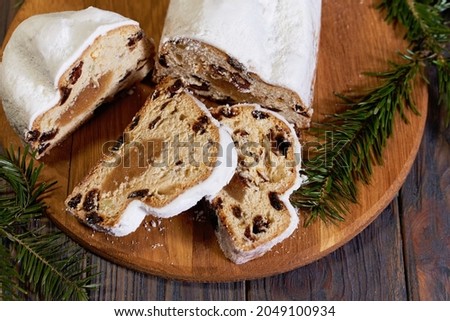 Christmas stollen on wooden background. Traditional christmas german dessert cut into pieces. Cake with nuts, raisins with marzipan and dried fruit on cutting board. baking for xmas Сток-фото © 