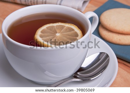 Inviting cup of hot tea with lemon and two fresh buttery sugar cookies