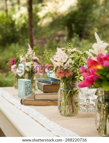 Reading garden table set up outside with bright pink flowers in vases