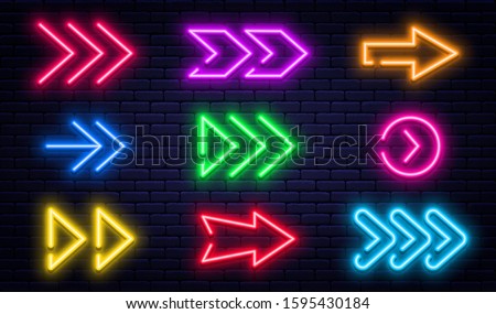 Set of glowing neon arrows. Glowing neon arrow pointers on brick wall background. Retro signboard with bright neon tubes in red, yellow, purple and blue colors. Vector