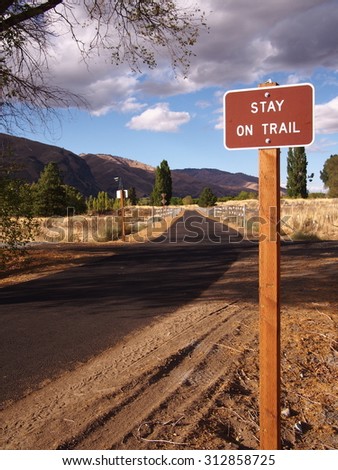 Sign reads for bikes to stay on trail.