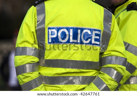 Shot of the back of a police officer\'s jacket with the word police written across the back