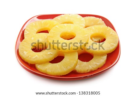 Canned pineapple rings on the red plate, isolated
