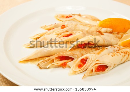 Pancakes with red caviar - traditional russian dish in restaurant