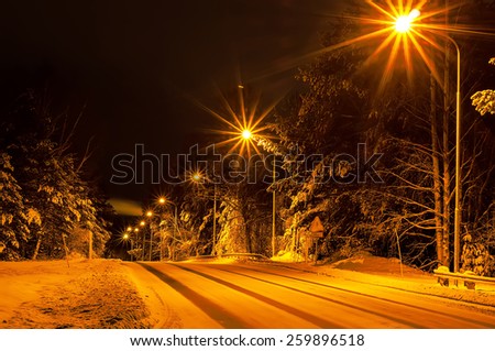 Winter road in the forest with lanterns, natural background