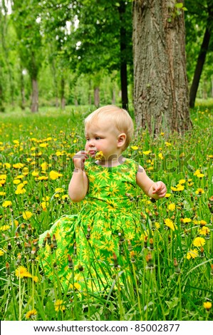 Little funny girl holding flower in her mouth
