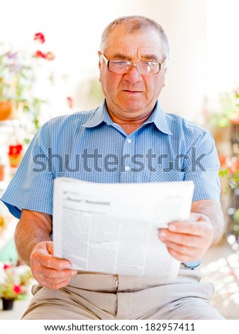 Elderly man read newspaper on the veranda