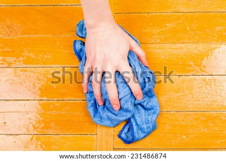Photo of a hand wash the floor with a rag