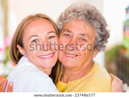 Happy elderly woman embracing with her daughter