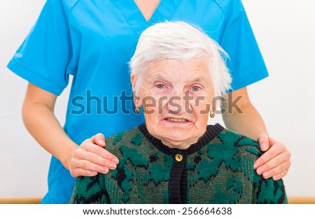Photo of elderly woman supported by young doctor