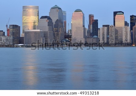 Downtown Manhattan Skyline at dusk with buildings reflecting the pink of the setting sun