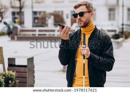 Young blinded man using phone and sending voice message Foto stock © 