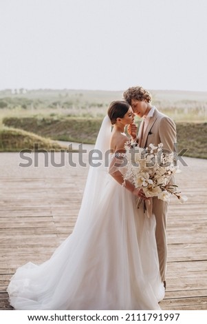 Similar – Image, Stock Photo Couple on their wedding apparel walking by the street