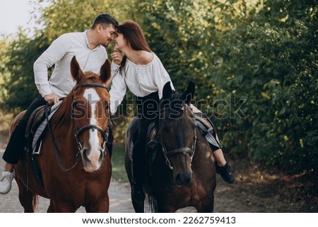 Similar – Image, Stock Photo A couple is horse riding on a meadow facing the distance. Romantic and active outdoor date. Autumn landscape, with young couple enjoying a horse riding. Overcast weather, beautiful horses.