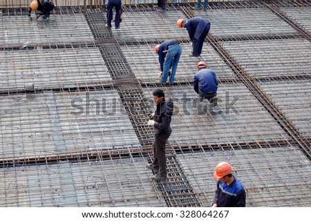 Workers assemble reinforcement for concrete pouring of the foundation. Construction of retail and office center \
