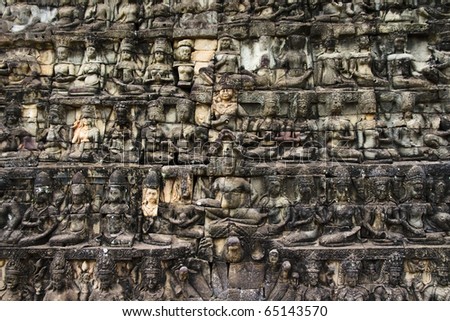 Huge detailed stone wall art carving of sitting figures, Angkor temples, Siem Reap, Cambodia