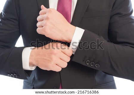 Elegant business man fixing his shirt sleeve from under the suit jacket