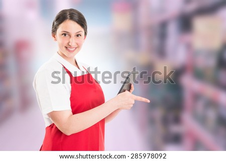 Modern hypermarket female worker using tablet to check supply