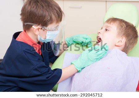 Kids as doctor and patient in dental office using dentist chair and tools