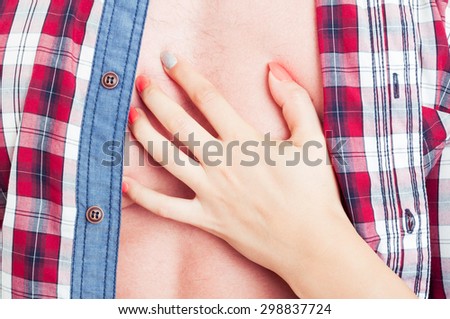 Sexy female hand touching man chest with open shirt. Passion and sensuality concept