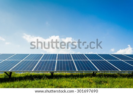 Solar panels on green field and blue sky, Renewable sun power concept