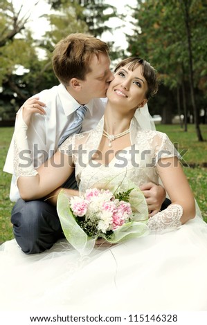 happy married  couple  on nature in park ,  sit on lawn and smile