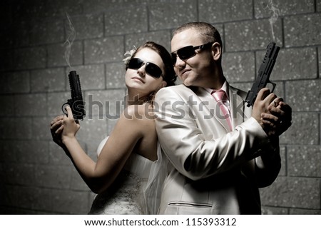newly married couple in white wedding dress, shoot of  black pistols