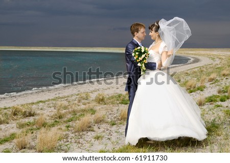 the beauty happy married  couple  stand on coast, puff wind, imminent  storm-cloud