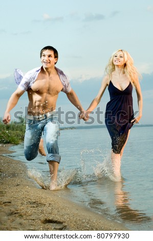 sexy beauty guy and girl outdoor in river, fast run on beach and happy smile
