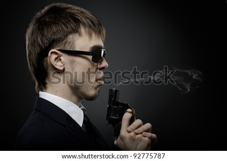 portrait  the  beautiful  man in black costume,  special-service agent or  body guard with  pistol