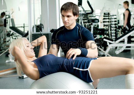 happy cutie athletic girl and guy,  execute exercise on sport-apparatus  and smile, in  sport-hall