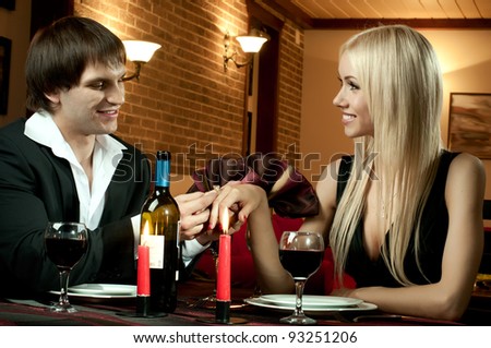 romantic evening date in hotel room, or supper in restaurant, guy make  engagement ring his beautiful woman