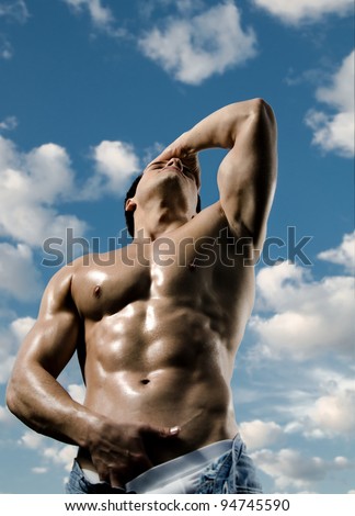 the very muscular handsome sexy guy on sky background, focus on face