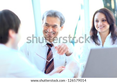 Smiling business people with paper work in board room