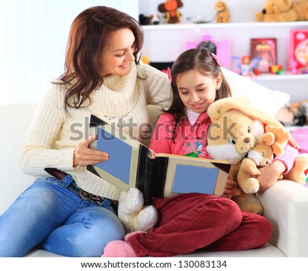 Happy mother and daughter reading a book together