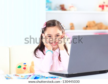 Cute little girl smiling and looking at laptop,Little girl using laptop