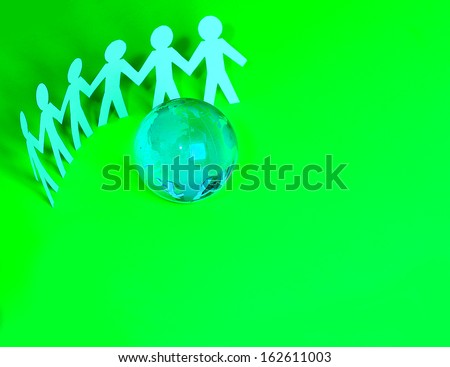 paper people standing around glass globe. conceptual idea for family, unity, and teamwork.
