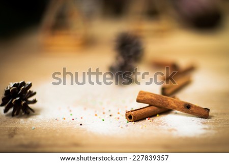 Cinnamon sticks on wood table with bundles of cinnamon in soft focus in background. Macro with extremely shallow dof. Selective focus limited to edges of closest sticks.