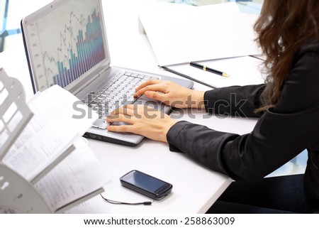 Female hands typing on the keyboard and while holding the mouse. Analysis of the graphs of sales.