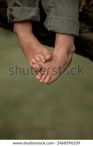 Similar – Image, Stock Photo Baby legs dangling from high chair; baby wearing turquoise outfit with bare feet against white wood background