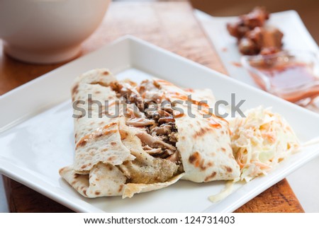 Caribbean style jerk chicken served in traditional roti and drizzled with sweet hot sauce. Served with a side of coleslaw.Focus on the chicken.