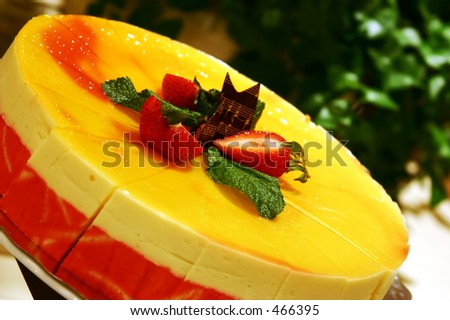 Delicious Mango Mousse Cake topped with strawberries and chocolate