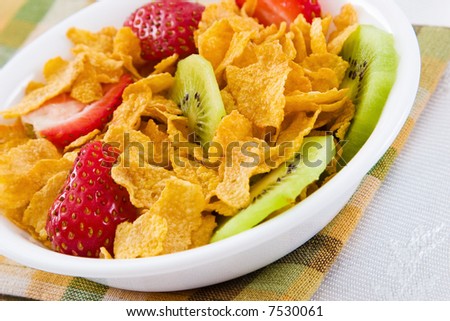 Delicious bowl of corn flakes with strawberries and kiwi fruit.